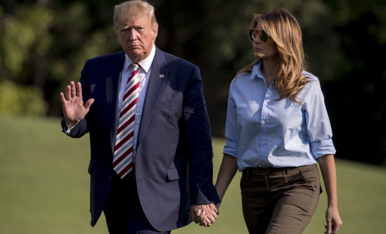 President Donald Trump waves to members of the media as he and first lady Melania Trump walk across the South Lawn of the White House in Washington, Sunday, Aug. 4, 2019, as they return from Bedminster, N.J. 