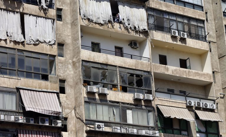 A woman hangs laundry at the 11th-floor building that houses the media office in a stronghold of the Lebanese Hezbollah group, in a southern suburb of Beirut, Lebanon, Sunday, Aug. 25, 2019. Two Israeli drones crashed in a Hezbollah stronghold in the Lebanese capital overnight without the militants firing on them, a spokesman for the group said Sunday.