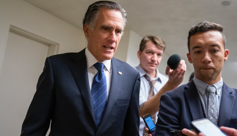 FILE - In this Sept. 11, 2019 file photo, Sen. Mitt Romney, R-Utah, takes questions from reporters as he arrives for votes on pending nominations, at the Capitol in Washington.