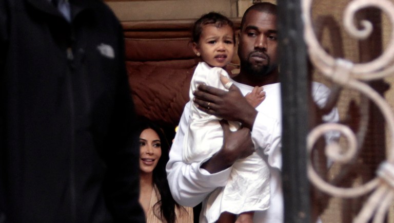 Kim Kardashian West, a US reality TV star, and her husband Kanye West holding their daughter North West, walk inside Armenian St. James Cathedral.