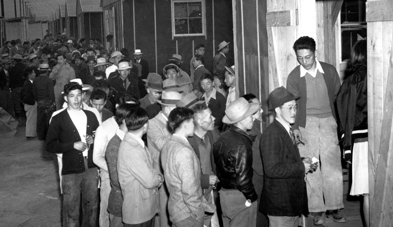Japanese citizens wait in line for their assigned homes at an internment camp reception center in Manzanar, Calif., on March 24, 1942. Many were forced from their homes in Los Angeles by the U.S. Army.