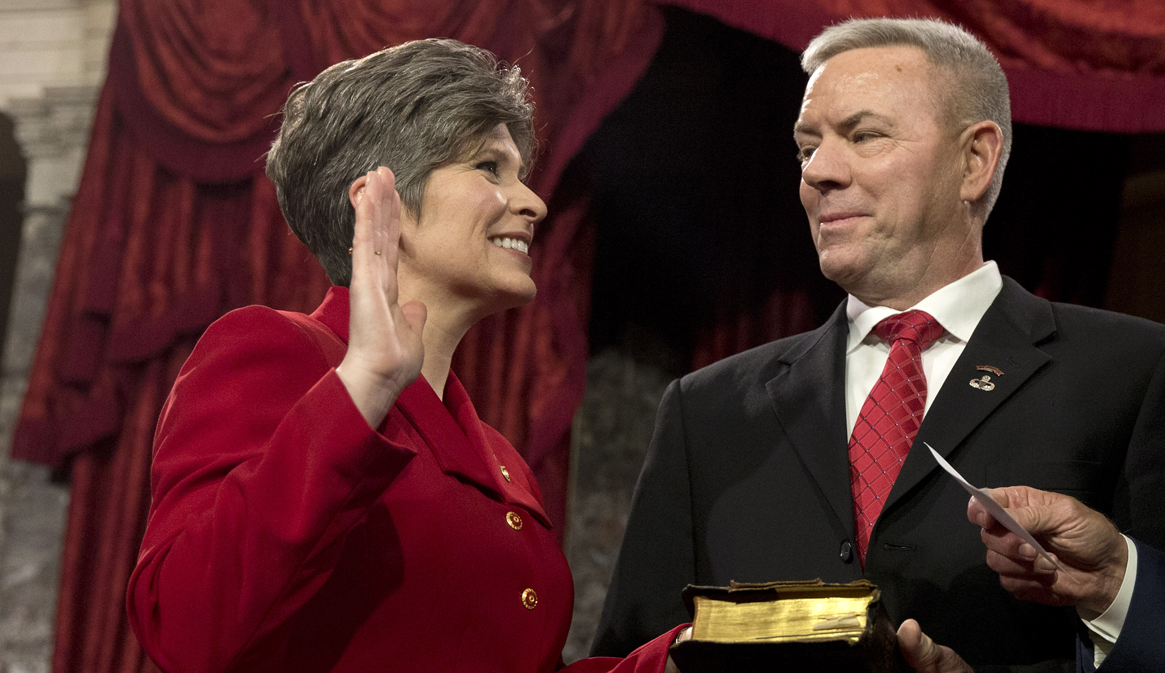 Vice President Joe Biden administers the Senate oath to Sen. Joni Ernst R-Iowa, with her husband Gail Ernst and daughter Elizabeth, during a ceremonial re-enactment swearing-in ceremony, Tuesday, Jan. 6, 2015, in the Old Senate Chamber of Capitol Hill in Washington. (AP Photo)