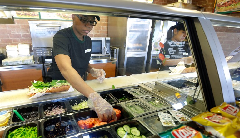FILE - In this March 3, 2015, file photo, workers make sandwiches at a Subway sandwich franchise in Seattle.