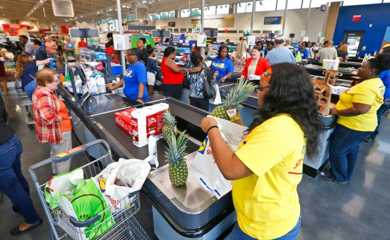 Shoppers check out and get their groceries bagged during the grand opening of a Lidl grocery store, Thursday, June 15, 2017, in Virginia Beach, Va.