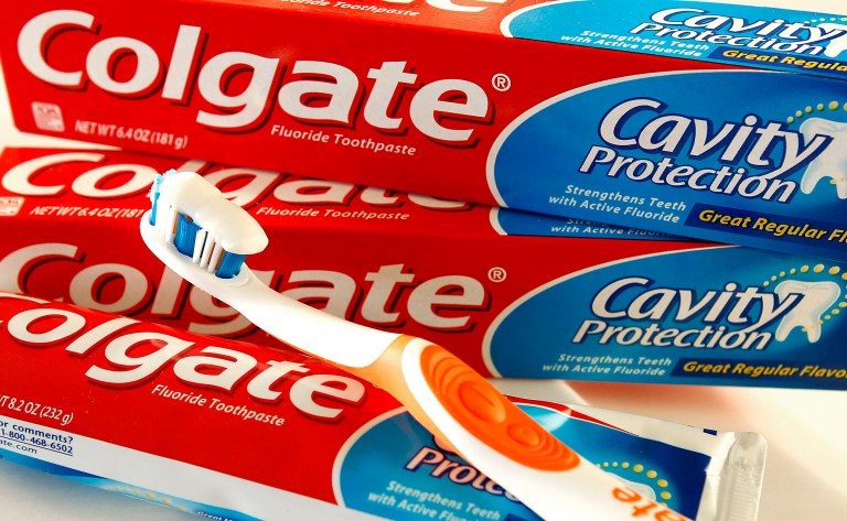 Colgate toothpaste and toothbrush are photographed.