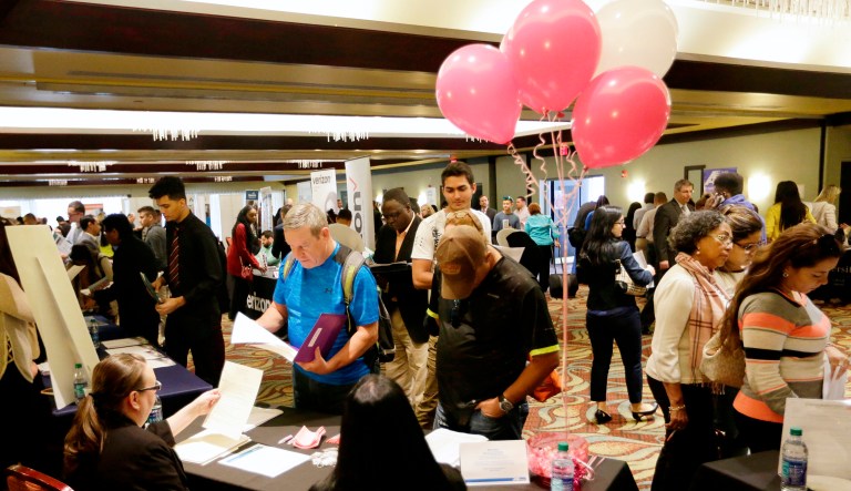 Job applicants talk with employees of Hialeah Park, at a JobNewsUSA job fair in Florida. On Friday, the U.S. government issues the May jobs report.