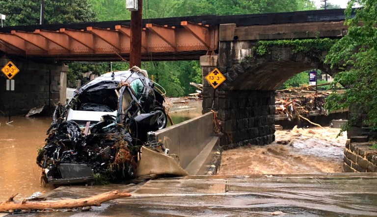 A damaged vehicle swept away by floodwaters stops by a utility pole in Ellicott City, Md., on Sunday. Roaring flash floods struck the Maryland city Sunday that had been wracked by similar devastation two years ago, when its main street turned into a raging river that reached the first floor of some buildings and swept away parked cars, authorities and witnesses say.