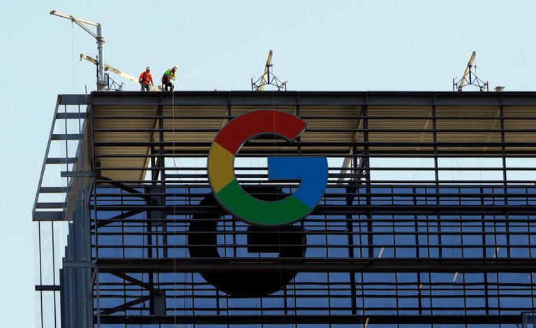 Men work atop a 29-story building, nicknamed 