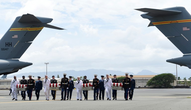 Military members carry transfer cases from a C-17 at a ceremony marking the arrival of the remains believed to be of American service members who fell in the Korean War at Joint Base Pearl Harbor-Hickam in Hawaii. 