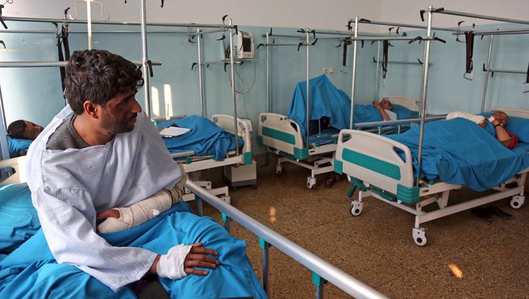 Injured men receive treatment at a hospital after Monday's Christmas Eve attack, in Kabul, Afghanistan.