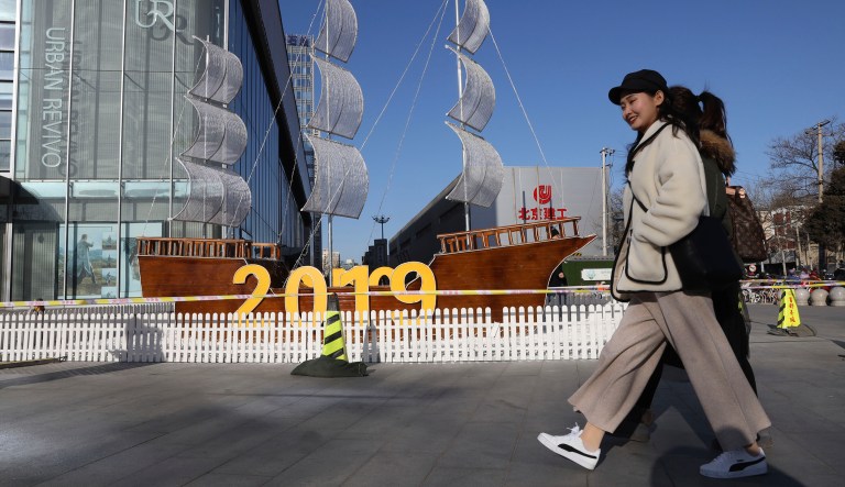 In this photo taken on Jan. 4, 2019, women pass by a new year decor outside a shopping mall in Beijing, China.