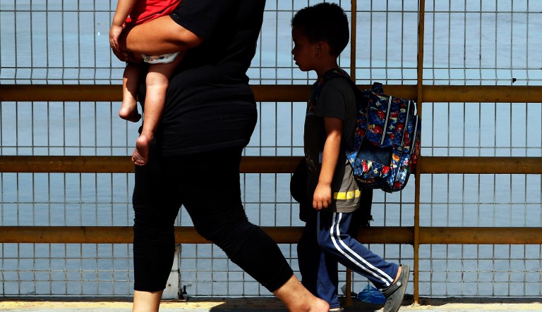 A mother and her two children walk across the Suchiate river bridge as Central American migrants cross the border between Guatemala and Mexico, near Ciudad Hidalgo, Chiapas State, Mexico, Thursday, Jan. 17, 2019. Hundreds of Central American migrants are walking and hitchhiking through the region as part of a new caravan of migrants hoping to reach the United States.