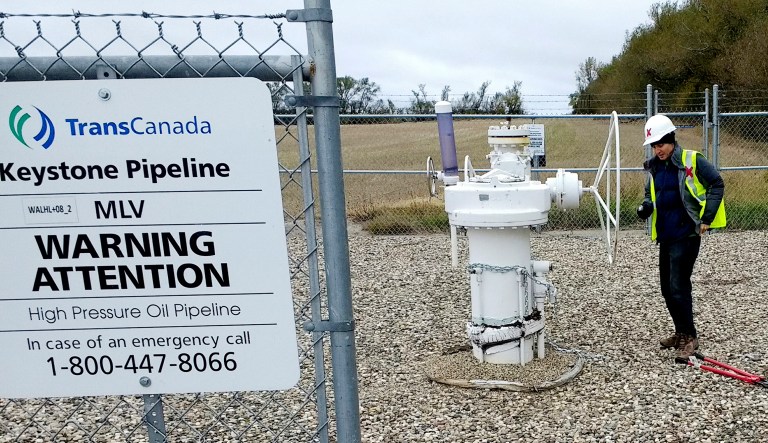 In this Oct. 11, 2016 photo provided by Samuel Jessup, climate change activist Michael Foster, of Seattle, turns an emergency shut-off valve on an oil pipeline in northeastern North Dakota.