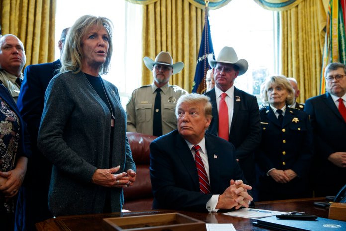 President Donald Trump listens as Mary Ann Mendoza, an "Angel Mom" who lost her son Brandon when he was killed by a drunk driver that was an undocumented immigrant, speaks before he signs the first veto of his presidency in the Oval Office of the White House, Friday, March 15, 2019, in Washington.  (AP Photo/Evan Vucci)