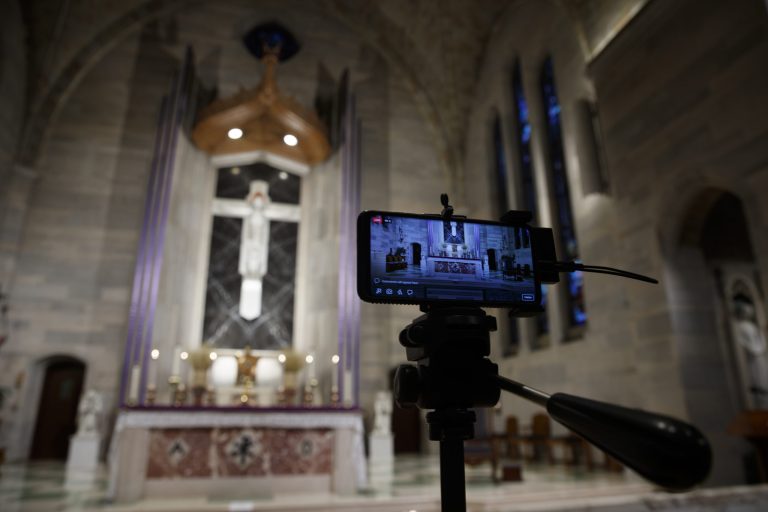 A smartphone is used to livestream a Eucharistic Adoration service at Saint Ann Catholic Church in Washington, Sunday night, March 29, 2020. A new survey shows people are embracing online services.