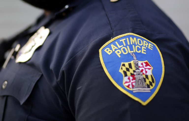 FILE - This March 31, 2016, file photo shows a shoulder patch of a Baltimore Police Department officer in Baltimore. Lawyers for the Baltimore police told a federal judge on Tuesday, April 21, 2020, that plans for camera-equipped planes to conduct aerial surveillance of the city should proceed, saying the crime-fighting tactic is constitutional despite the objections of civil liberties advocates. 