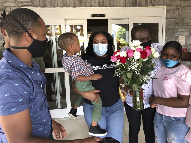 Teisha Roberts, center, a nursing director, is greeted by her family as she prepares to leave Park Springs elder care facility in Stone Mountain, Ga., Saturday, June 13, 2020. More Americans are eager for expanded family and medical leave during the coronavirus crisis.