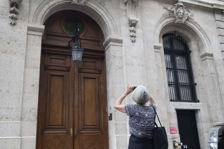 In this Aug. 13, 2019 file photo, a pedestrian stops to take a photo of Jeffrey Epstein's townhouse on the Upper East Side of Manhattan, in New York. (AP Photo/Mary Altaffer, File)