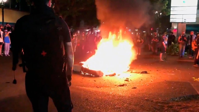 In this image taken from video a mattress burns in the street near the Portland Police Bureau's North Precinct Sunday night, Sept. 6, 2020, in Portland, Ore. Protesters have gathered for more than 100 days following the death of George Floyd in Minneapolis.