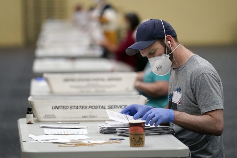 Workers prepare mail-in ballots for counting, Wednesday, Nov. 4, 2020, at the convention center in Lancaster, Pa., following Tuesday's election.