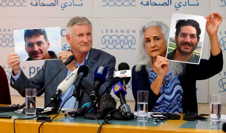 In this July 20, 2017, file photo, Marc and Debra Tice, the parents of Austin Tice, who has been missing in Syria since August 2012, hold up photos of him during a new conference, at the Press Club, in Beirut, Lebanon. 