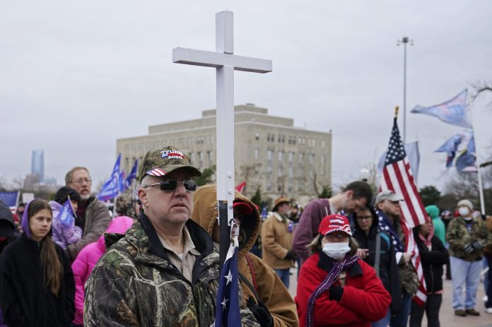 Kenny Womack, of Edmond, Okla., holds a cross at a Trump rally at the state Capitol on January 6 in Oklahoma City.