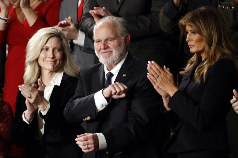 In this Feb. 4, 2020 file photo, Rush Limbaugh reacts as first Lady Melania Trump, and his wife Kathryn, applaud, as President Donald Trump delivered his State of the Union address to a joint session of Congress.  Limbaugh, the talk radio host who became the voice of American conservatism, died Feb. 17, 2021. 