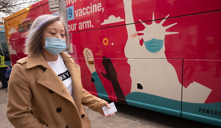 A woman carries her vaccination card after receiving the Johnson & Johnson COVID-19 vaccine, Wednesday, April 7, 2021 in the Sunset Park neighborhood of New York.