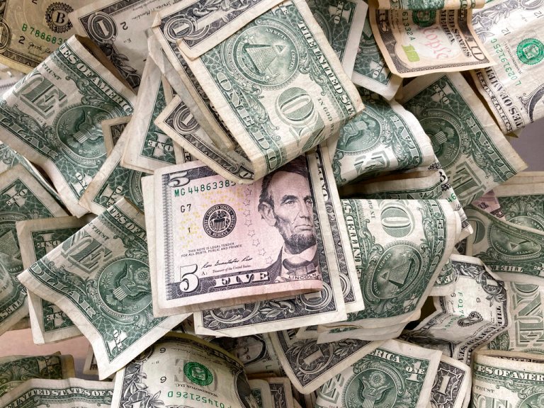Dollar bills are deposited in a tip box, May 24, 2021 in New York.