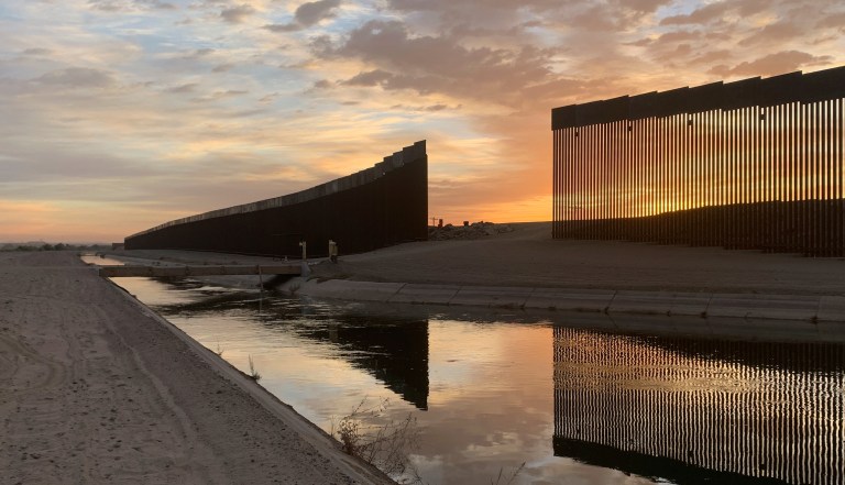 The sun sets above the U.S.-Mexico border wall seen in Yuma, Ariz. Wednesday, June 9, 2021.