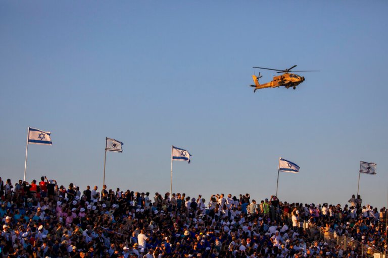 An Israeli air force Apache fly over spectators during a graduation ceremony for new pilots in Hatzerim air force base near the southern Israeli city of Beersheba, Israel, Thursday, June 24, 2021.