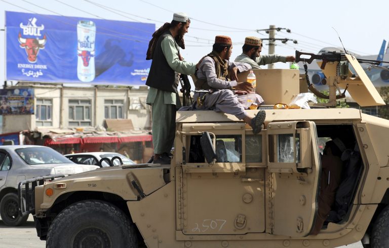 Taliban fighters stand guard in front of Hamid Karzai International Airport in Kabul, Afghanistan, on Aug. 16.