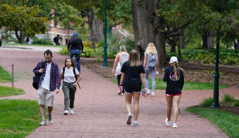 Students walk to and from classes on the Indiana University campus, Thursday, Oct. 14, 2021, in Bloomington, Ind.