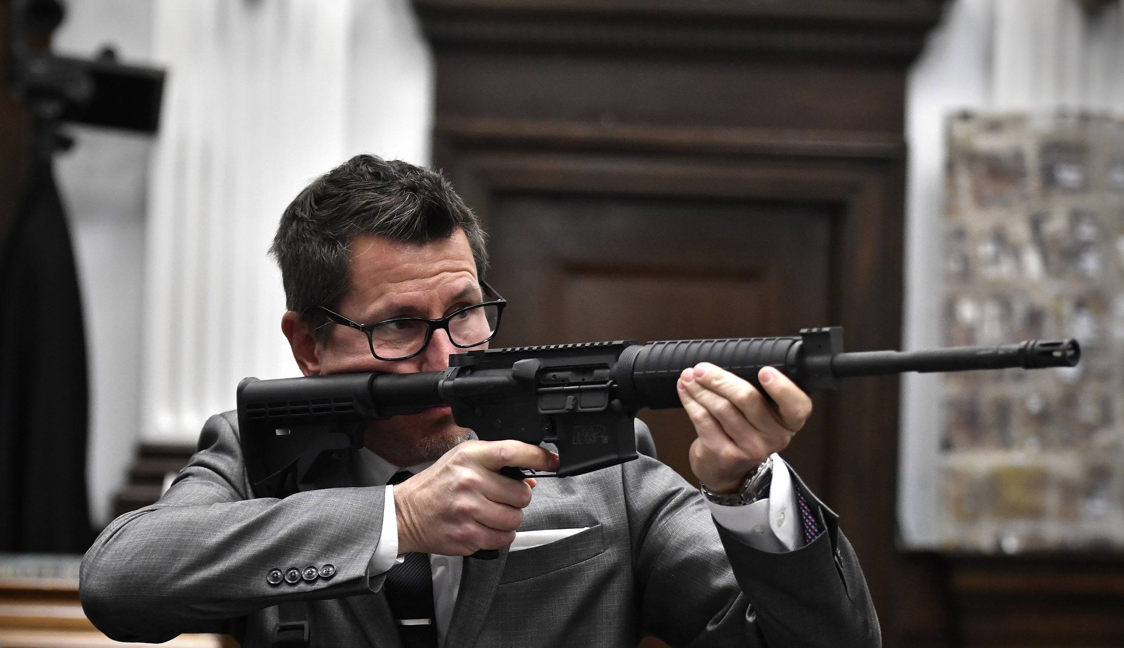 Binger holds Kyle Rittenhouse's gun as he gives the state's closing argument