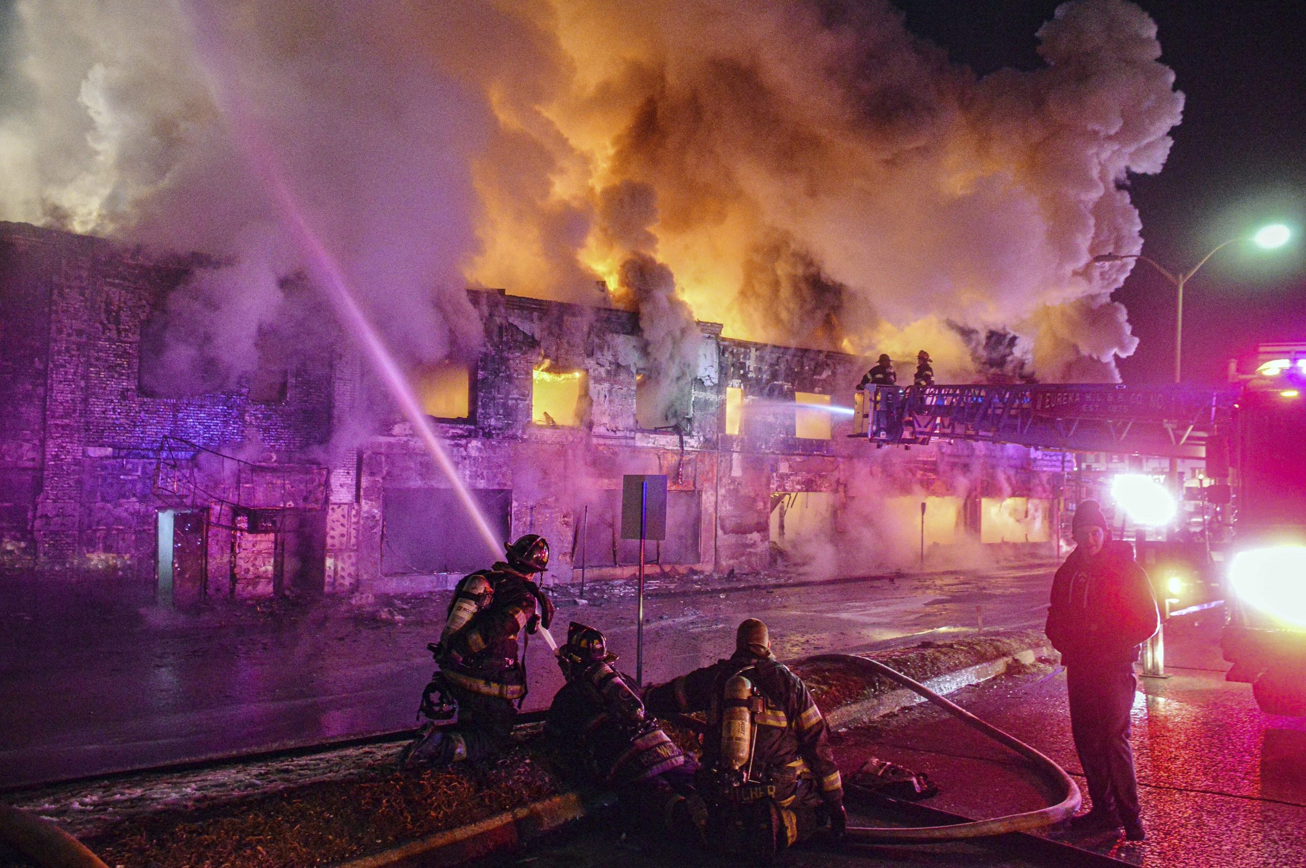 A tanker carrying gasoline lost control, crashed into a vacant building, and burst into flames on Long Island early Wednesday, injuring the truck's driver and three firefighters who responded, authorities said.