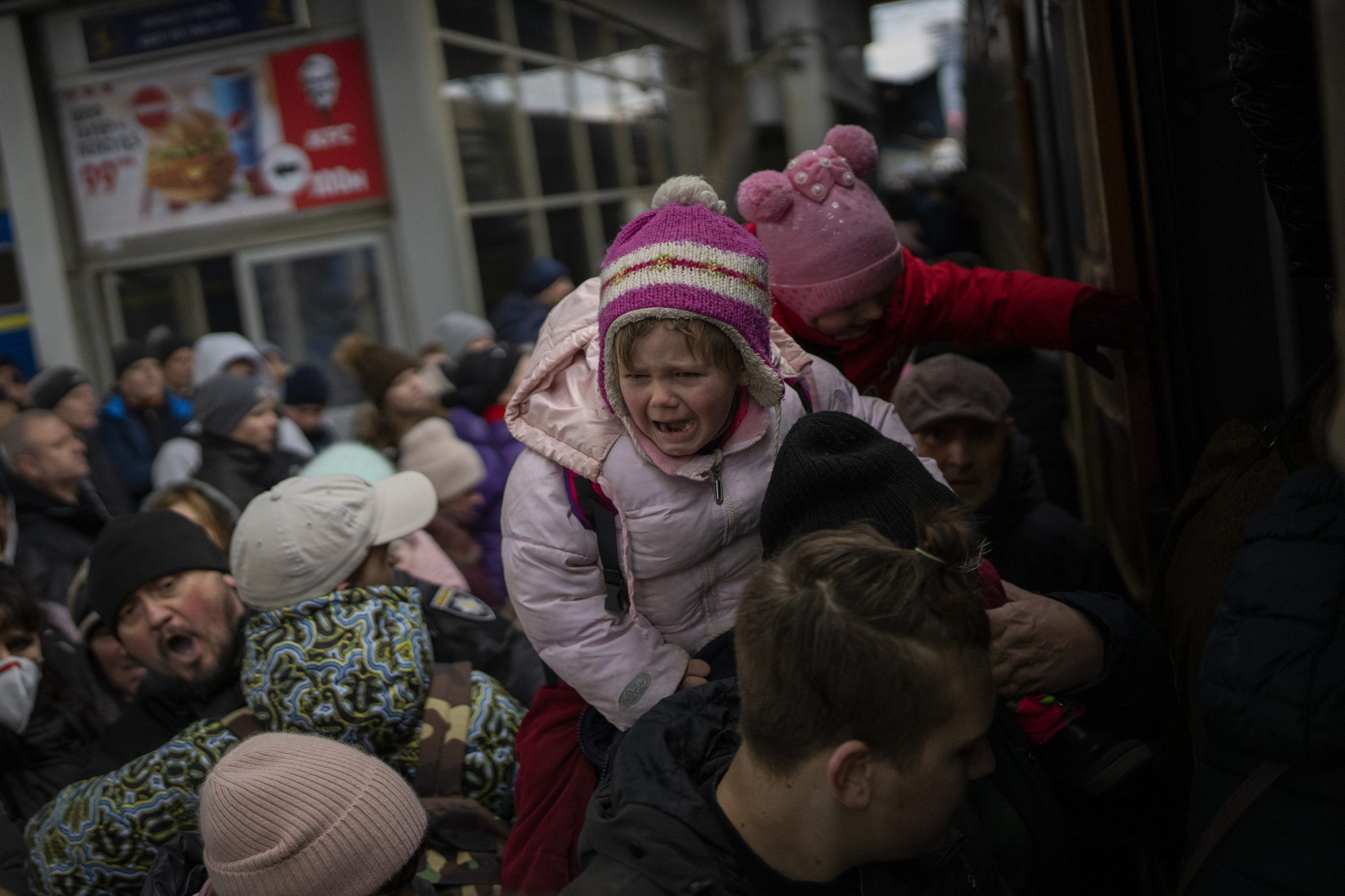 People holding their children struggle to get on a train to Lviv at the Kyiv station in Ukraine on March 7, 2022.