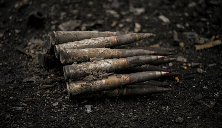 Large caliber ammunition lies on the ground next to a destroyed Russian tank in Irpin, on the outskirts of Kyiv, Ukraine, Wednesday, March 9, 2022.