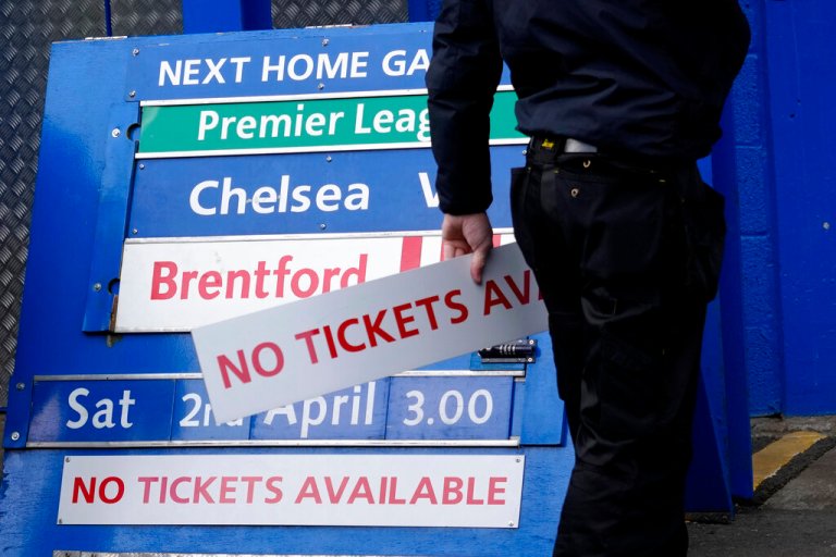 A member of ground staff adjusts an upcoming match board ahead of the English Premier League soccer match between Chelsea and Newcastle United at Stamford Bridge stadium in London, Sunday, March 13, 2022. The Premier League has disqualified Roman Abramovich from running Chelsea after the club owner was sanctioned by the British government over Russia's war on Ukraine. (AP Photo/Kirsty Wigglesworth)