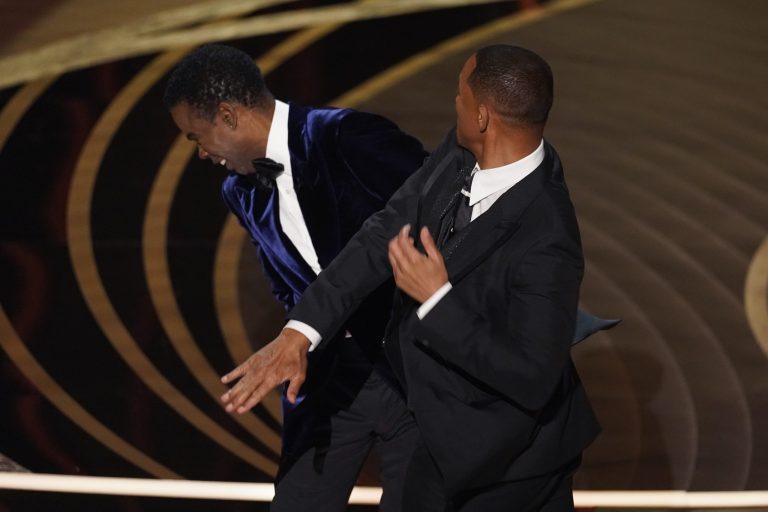 Will Smith, right, hits presenter Chris Rock onstage at the Oscars.