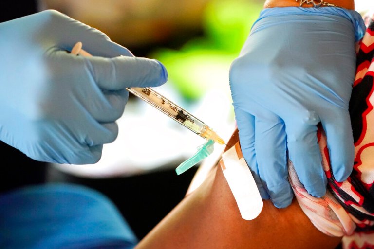 A Jackson-Hinds Comprehensive Health Center nurse administers a Moderna COVID-19 vaccine at an inoculation station next to Jackson State University in Jackson, Miss., Tuesday, July 19, 2022. 