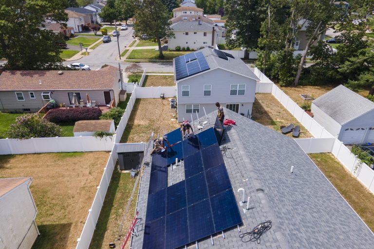 People who work for NY State Solar, a solar panel sales and installation company, install 415 DC watt solar panels onto the roof of a home in Massapequa, New York, on Thursday, August 11, 2022. The Inflation Reduction Act would pump $369 billion into measures to fight climate change, boost energy security and lower electricity costs for consumers. Those investments would mostly take the form of financial incentives, tax breaks and rebates, for households and businesses. (AP Photo/Ted Shaffrey)