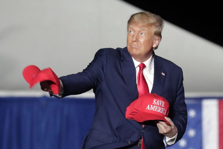 Former President Donald Trump tosses caps to the crowd as he holds a rally Friday, Sept. 23, 2022, in Wilmington, N.C.