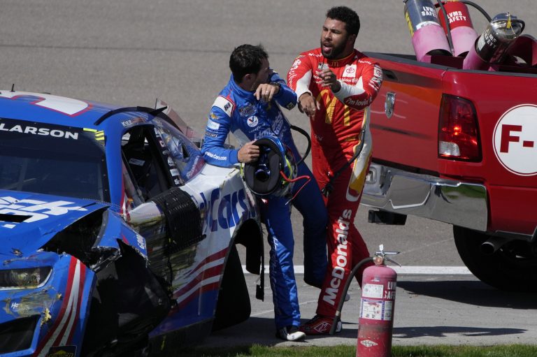 Bubba Wallace, right, pushes Kyle Larson after the two crashed during a NASCAR Cup Series auto race Sunday, Oct. 16, 2022, in Las Vegas.