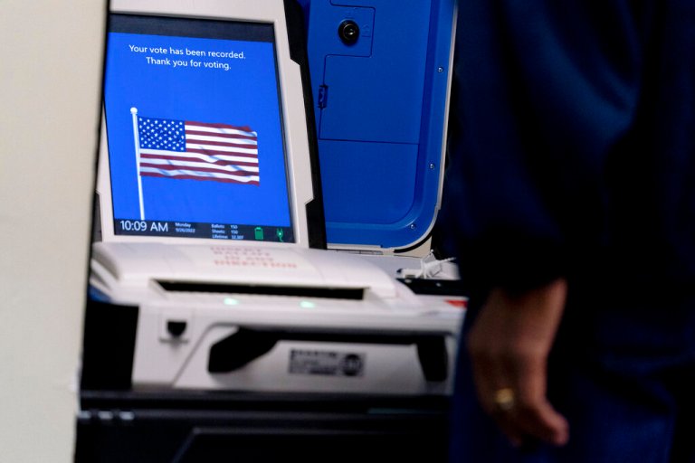 A voter submits a ballot at an early voting location in Alexandria, Va., on Sept. 26, 2022.