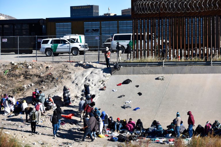 Migrants wait to cross the U.S.-Mexico border from Ciudad JuÃ¡rez, Mexico, next to U.S. Border Patrol vehicles in El Paso, Texas, Wednesday, Dec. 14, 2022. 