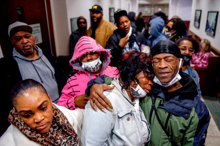Latryna Sims, partner of Calvin Munerlyn, center, cries on the shoulder of his uncle Ramon Munerlyn, as the family celebrates outside the courtroom after three defendants charged in the fatal shooting of the security guard at a Family Dollar store in Flint, Mich., were sentenced to life in prison.