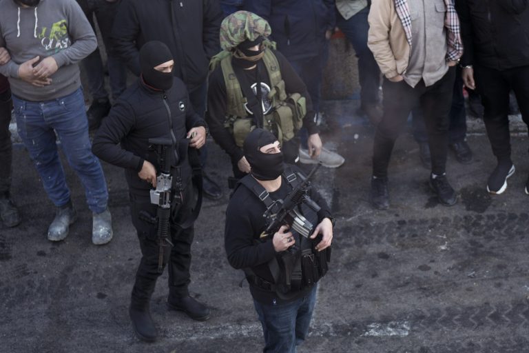 A Palestinian gunman fires into the air during the funeral for 10 men killed in clashes with Israeli troops in the West Bank city of Nablus, Wednesday, Feb. 22, 2023. 