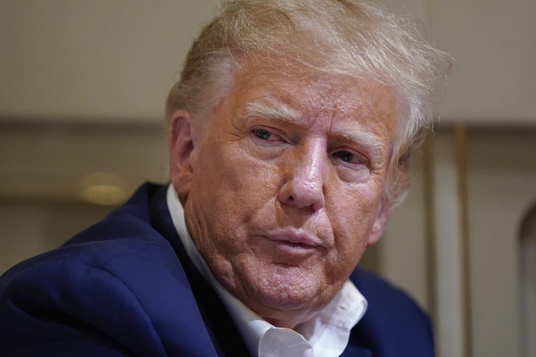 Former President Donald Trump listens as he speaks with reporters while in flight on his plane after a campaign rally at Waco Regional Airport, in Waco, Texas, Saturday, March 25, 2023, while en route to West Palm Beach, Florida. 