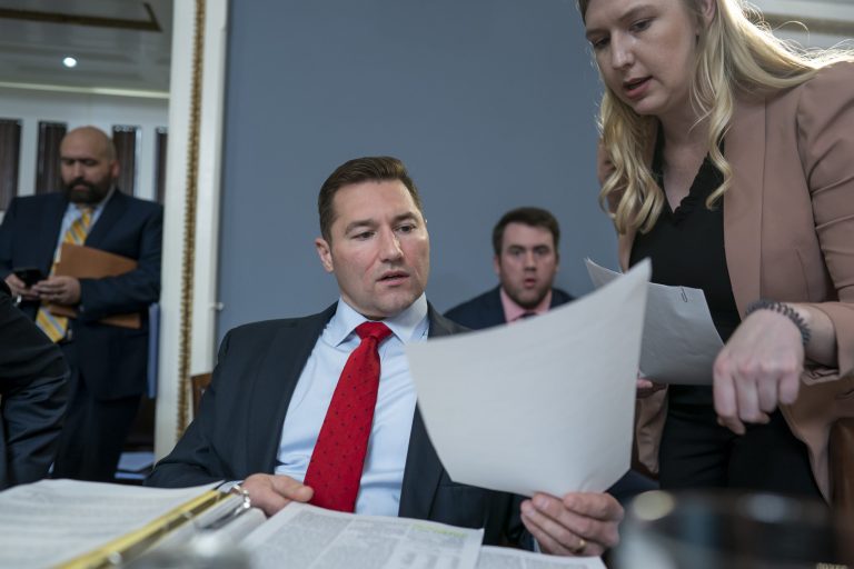 Rep. Guy Reschenthaler, R-Pa., talks with an aide as the House Rules Committee meets to prepare Speaker Kevin McCarthy's debt ceiling package for the floor, on Capitol Hill in Washington, Tuesday, April 25, 2023. 