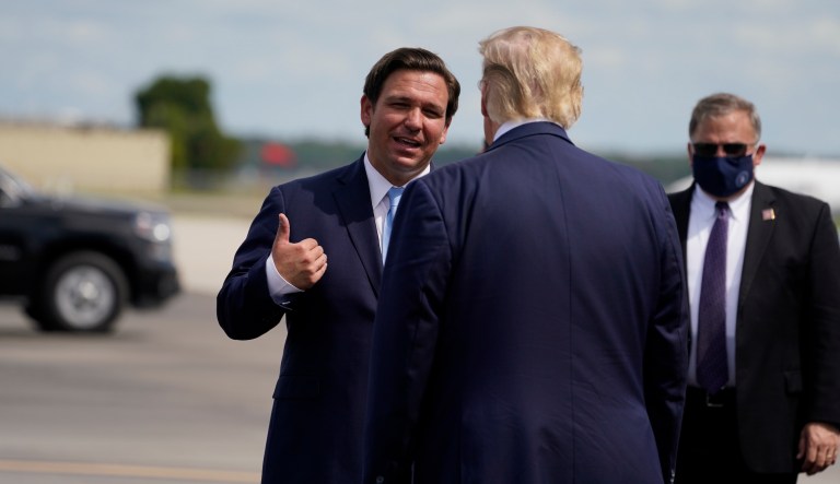President Donald Trump speaks with Florida Gov. Ron DeSantis as he arrives at Southwest Florida International Airport, Oct. 16, 2020, in Fort Myers, Fla.